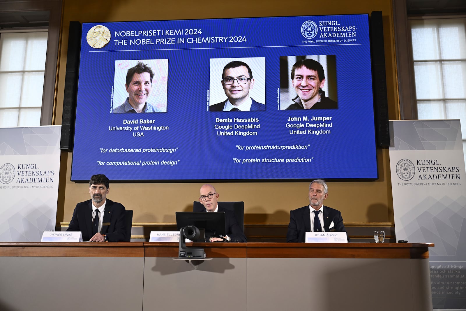 Johan Åqvist, member of the Nobel Committee for Chemistry, Hans Ellegren, Permanent Secretary and Heiner Linke, Chairman of the Nobel Committee for Chemistry award this years Nobel Prize in Chemistry to David Baker, Demis Hassabis, and John M Jumper at the Royal Swedish Academy of Sciences, in Stockholm, Sweden, Wednesday, Oct. 9, 2024. (Christine Olsson/TT News Agency via AP)