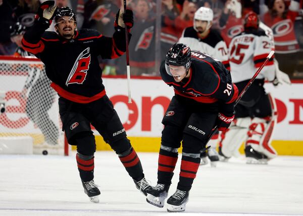 Carolina Hurricanes' Sebastian Aho (20) celebrate his game-winning goal with Seth Jarvis (24) during the second overtime period of Game 5 of an NHL hockey first-round playoff series against the New Jersey Devils in Raleigh, N.C., Tuesday, April 29, 2025. (AP Photo/Karl DeBlaker)