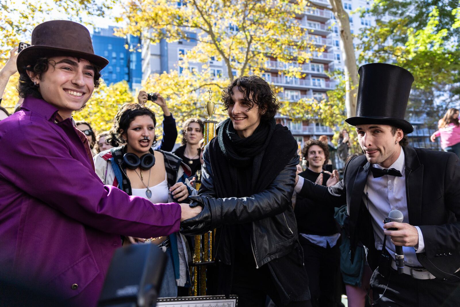 Finalists Miles Mitchell, left and Zander Dueve, center, shake hands at the Timothee Chalamet lookalike contest near Washington Square Park, Sunday, Oct. 27, 2024, in New York. (AP Photo/Stefan Jeremiah)