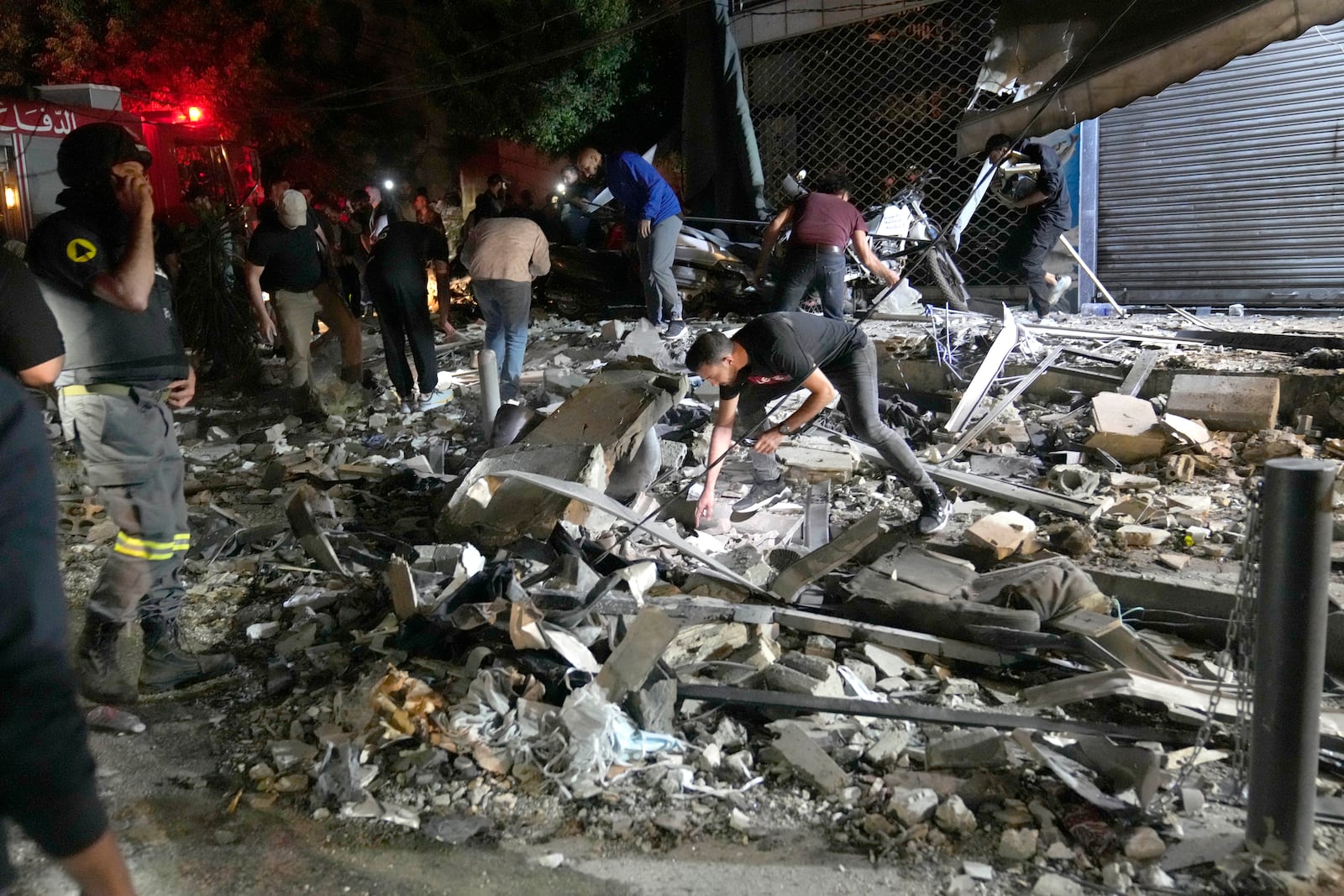 People work to clear debris after an airstrike that hit an apartment building in Beirut, Lebanon, Thursday, Oct. 3, 2024. (AP Photo/Hussein Malla)