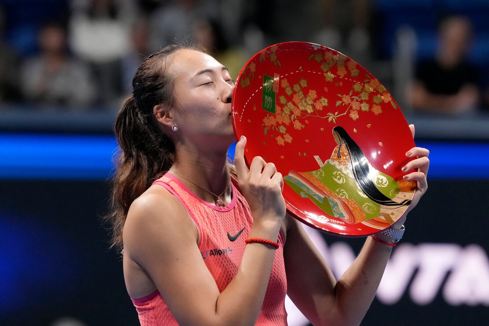 China's Zheng Qinwen kisses her trophy after winning the Pan Pacific Open women's tennis tournament at Ariake Coliseum, in Tokyo, Sunday, Oct. 27, 2024. (AP Photo/Eugene Hoshiko)