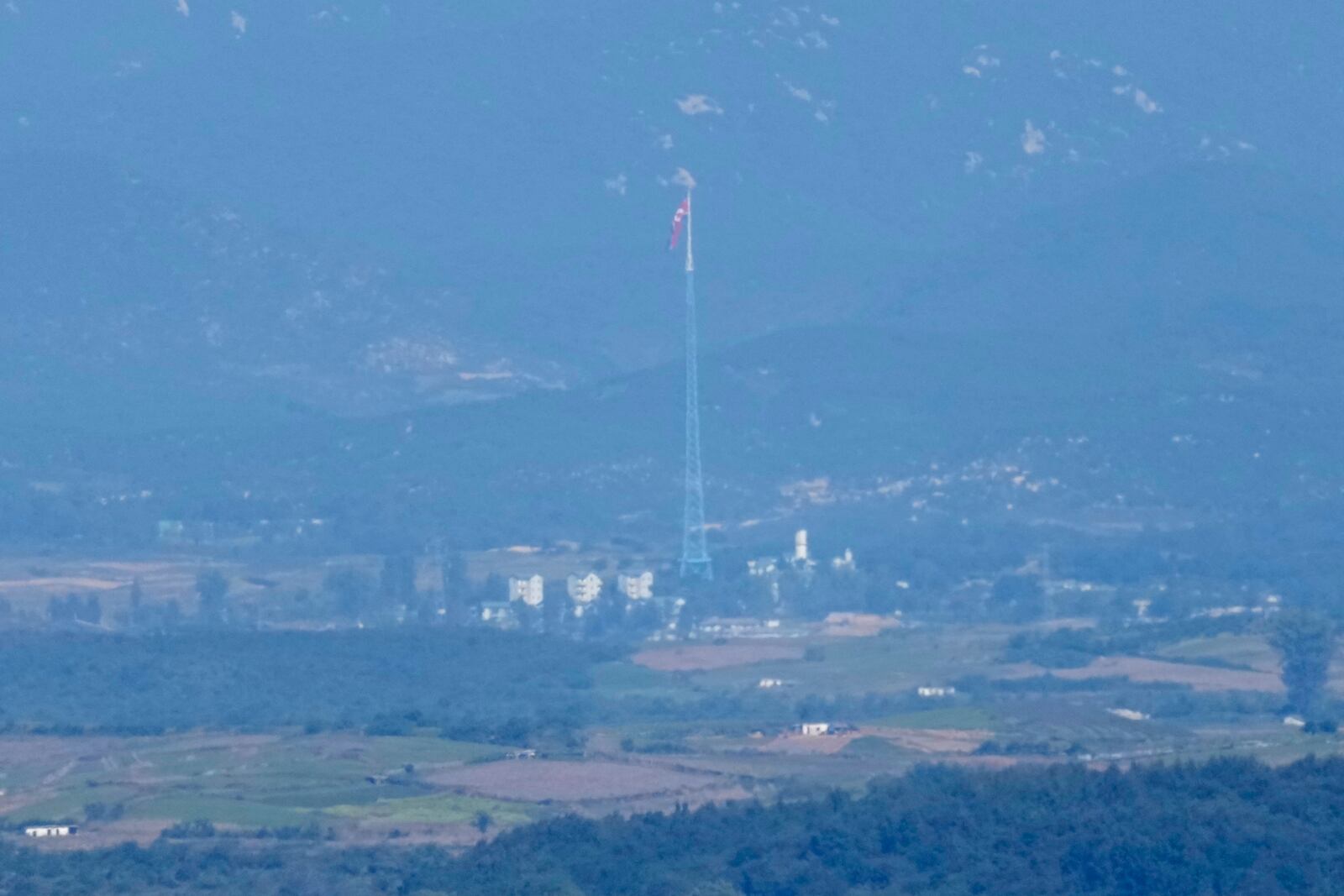 A North Korean flag flutters in the wind atop a 160-meter (525-foot) tower in the North's Kijong-dong village near the truce village of Panmunjom, seen from Paju, South Korea, near the border with North Korea, Friday, Oct. 4, 2024. (AP Photo/Lee Jin-man)