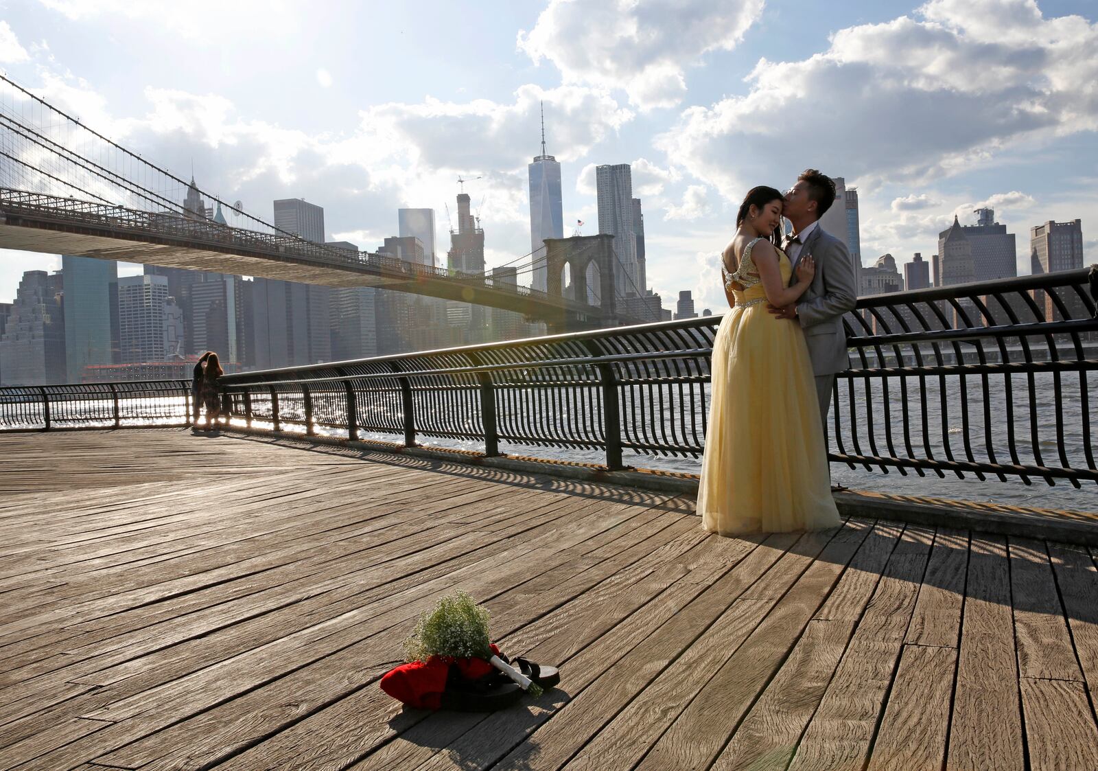 FILE - A couple poses for their wedding photos in Brooklyn Bridge Park in New York on June 30, 2016. (AP Photo/Kathy Willens, File)