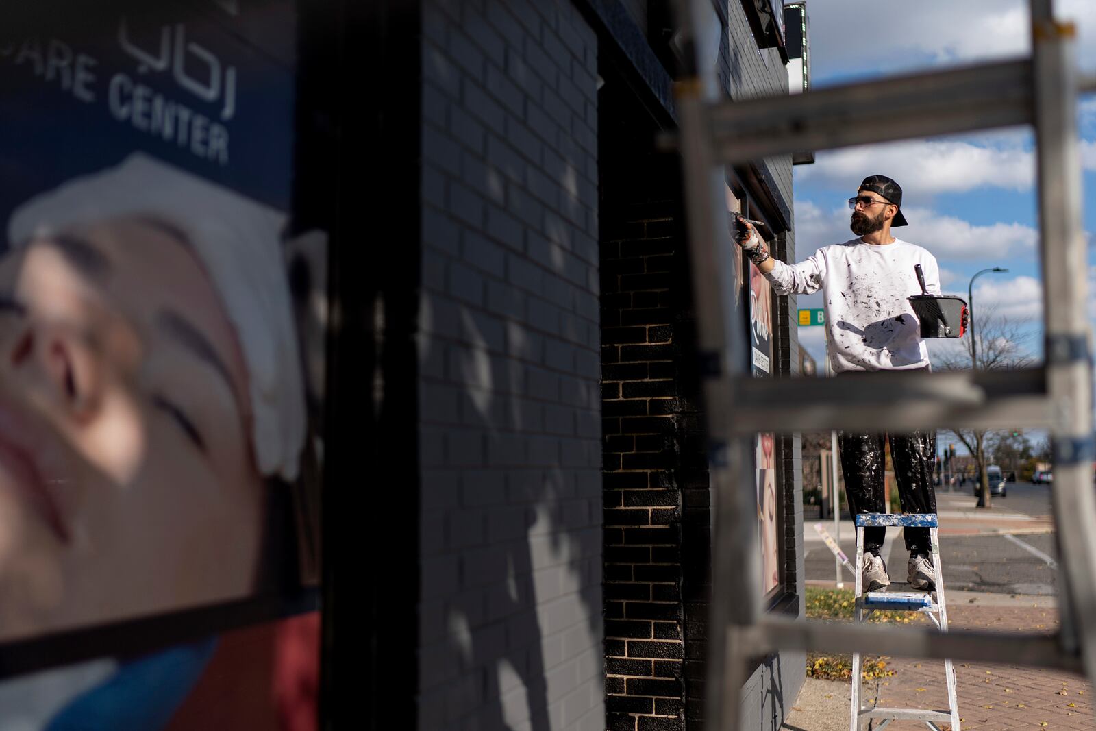 Adam Hameed, paints the exterior of a skin care center, Wednesday, Nov. 6, 2024, in Dearborn, Mich, the nation's largest Arab-majority city. "For me I worry about my kids and the economy. Everything's too expensive and I can't buy what I want for my kids," said Hameed who voted for President-elect Donald Trump. "I want my kids to see me strong and doing well." (AP Photo/David Goldman)