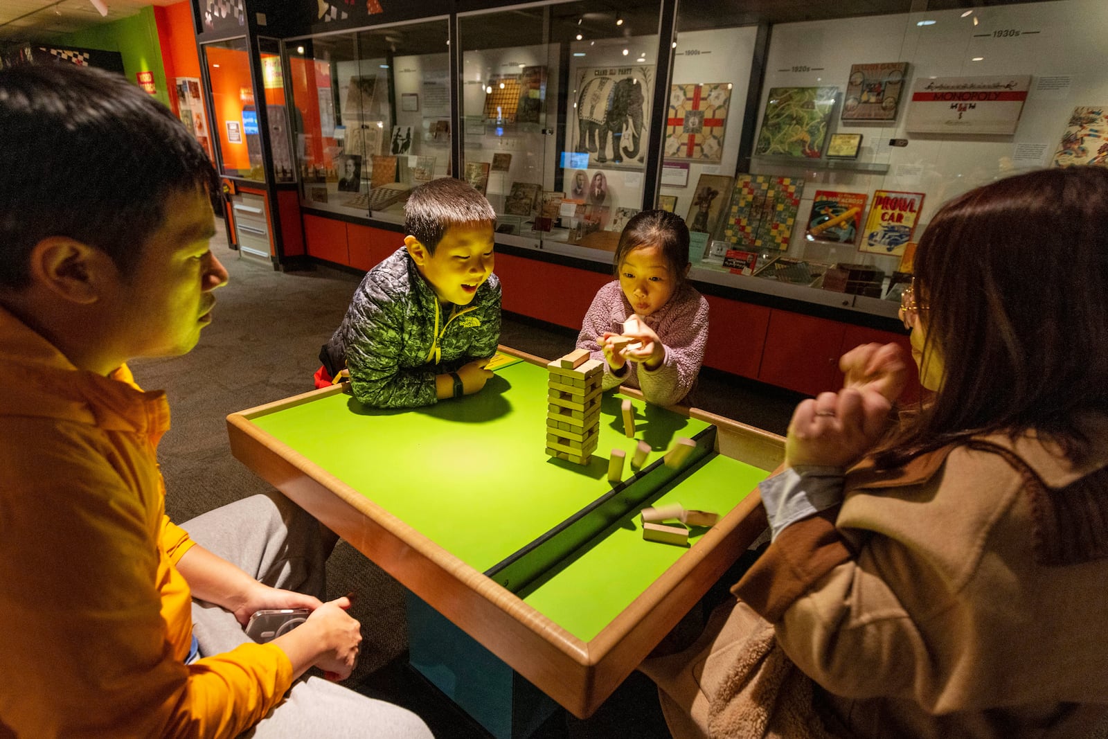 Jesse and Lydia Xu of Toronto play a game of Jenga with their kids Casper, 9, and Lydia, 8, at The Strong National Museum of Play, Tuesday, Oct. 15, 2024, in Rochester, N.Y. (AP Photo/Lauren Petracca)