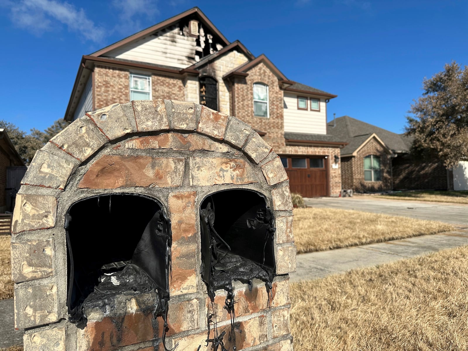 A mailbox melted by the heat of a pipeline fire sits in front of a home in Deer Park, Texas, on Thursday, Sept. 19, 2024. (AP Photo/Juan A. Lozano)