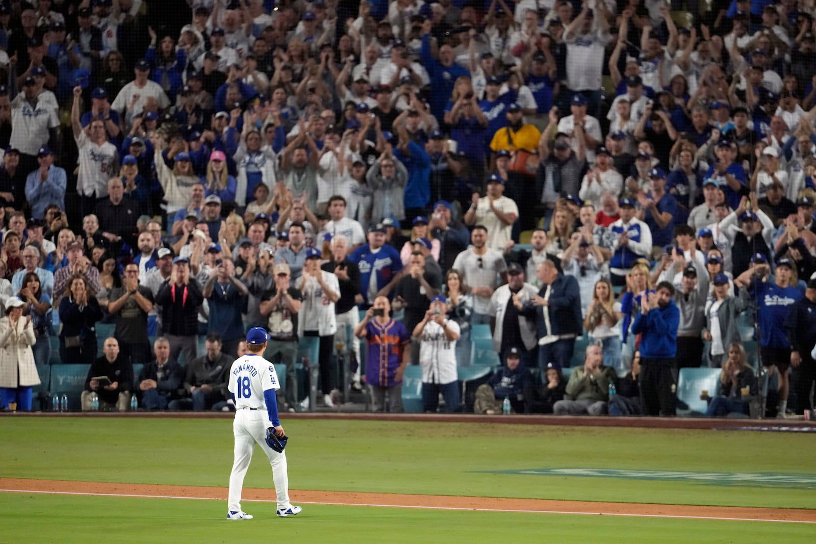 Fans cheer as Los Angeles Dodgers starting pitcher Yoshinobu Yamamoto (18) leaves the game during the seventh inning in Game 2 of the baseball World Series against the New York Yankees, Saturday, Oct. 26, 2024, in Los Angeles. (AP Photo/Julio Cortez)