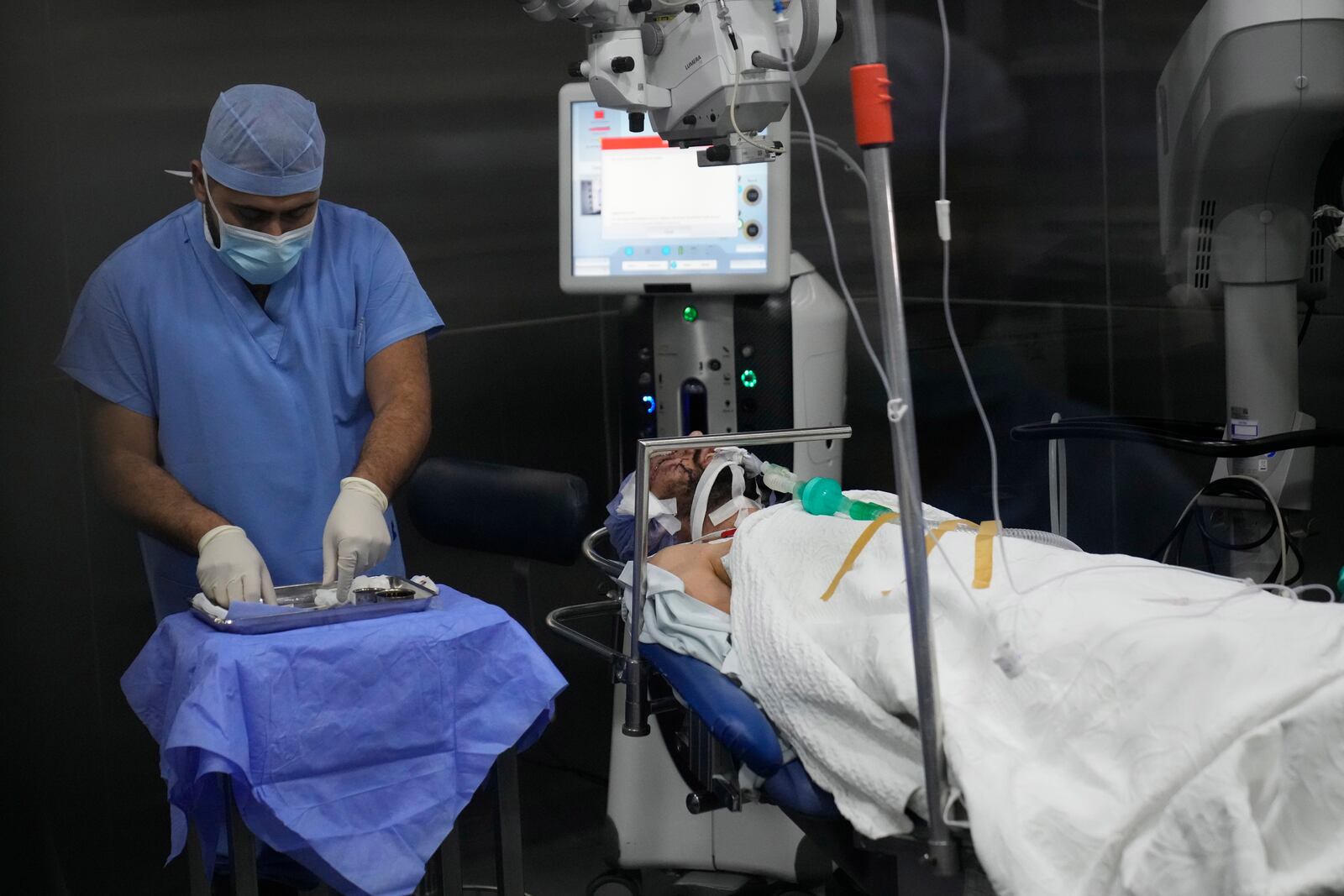 A man who was injured in the explosion of one of the handheld devices, lies inside an operation room ahead of an eye surgery at the Eye Specialist hospital, in Beirut, Lebanon, Friday, Sept. 20, 2024. (AP Photo/Hussein Malla)