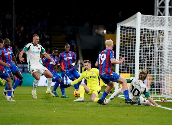 Newcastle United's Anthony Gordon (right) crosses the ball into the box resulting in an own goal by Crystal Palace's Marc Guehi during the English Premier League soccer match between Crystal Palace and Newcastle United at Selhurst Park, London, Saturday Nov. 30, 2024. (Ben Whitley/PA via AP)