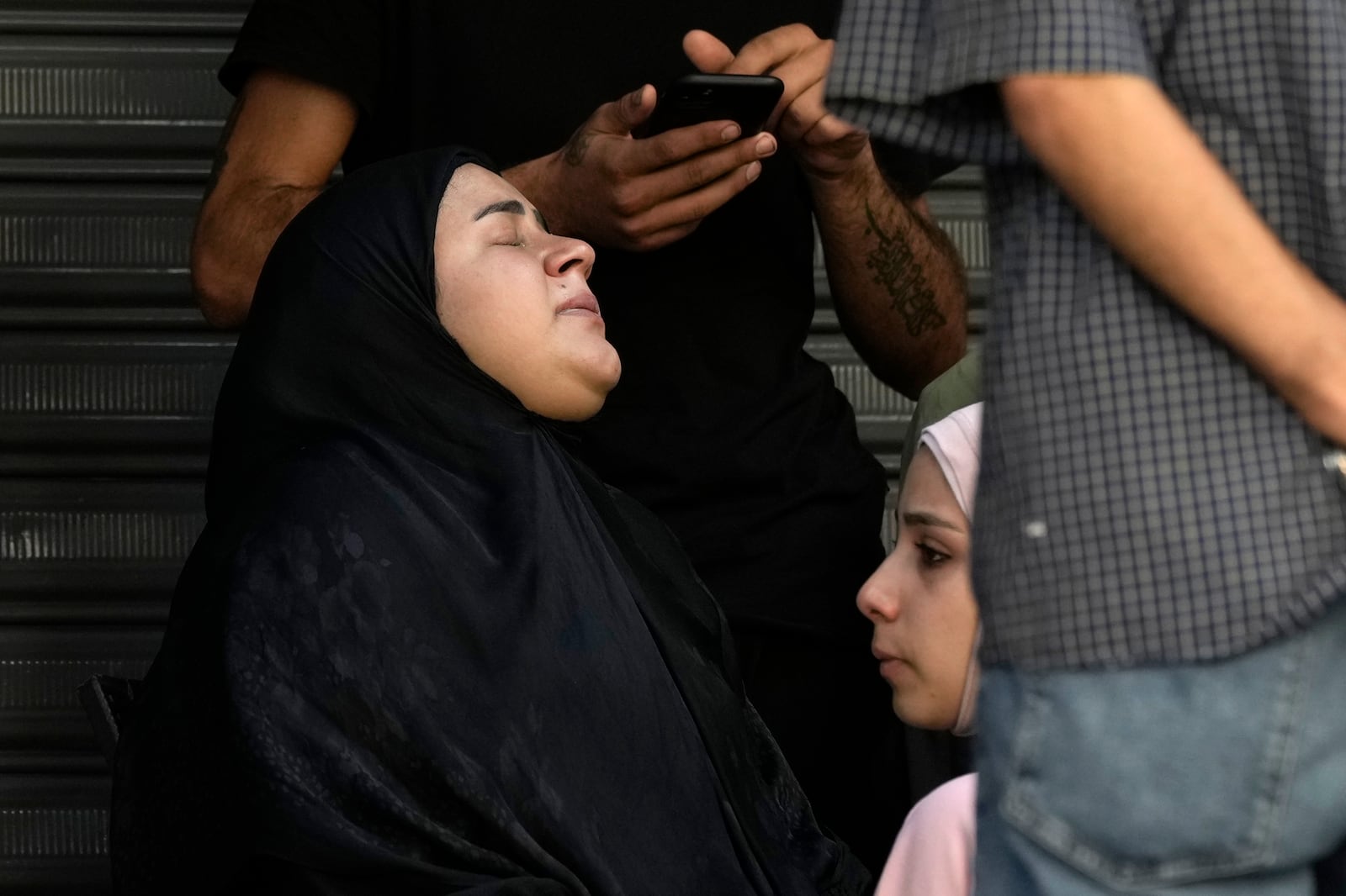 Relatives of the victims react near the site of Friday's Israeli strike in Beirut's southern suburbs, Saturday, Sept. 21, 2024. (AP Photo/Bilal Hussein)