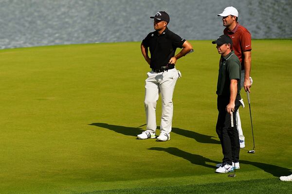 Xander Schauffele, Rory McIlroy, of Northern Ireland, and Scottie Scheffler line up a their putts on the 14th hole during the first round of the PGA Championship golf tournament at the Quail Hollow Club, Thursday, May 15, 2025, in Charlotte, N.C. (AP Photo/David J. Phillip)