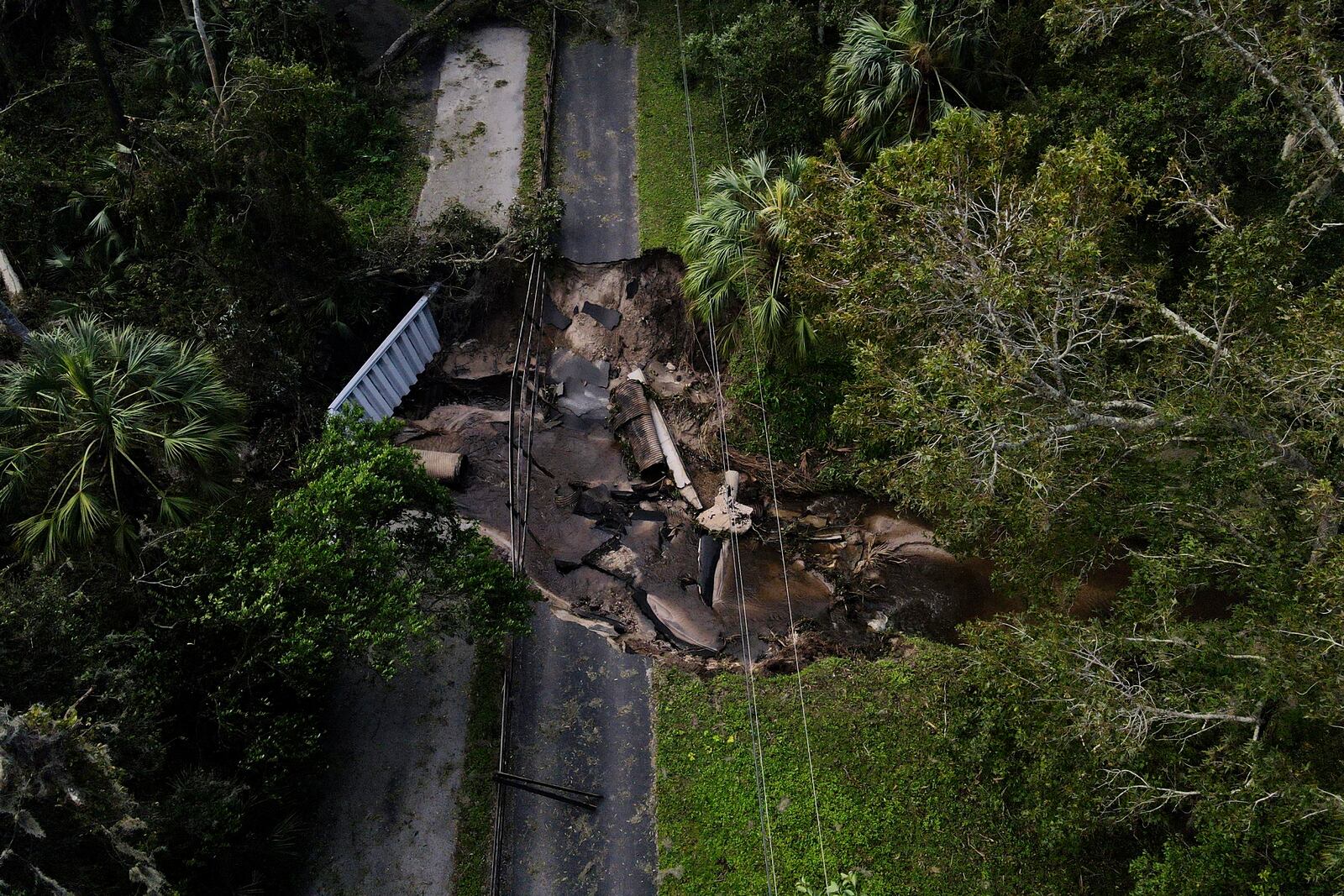 A bridge going over a small creek is seen damaged by Hurricane Milton, Friday, Oct. 11, 2024, in Riverview, Fla. The road is the only access point into a community. (AP Photo/Julio Cortez)