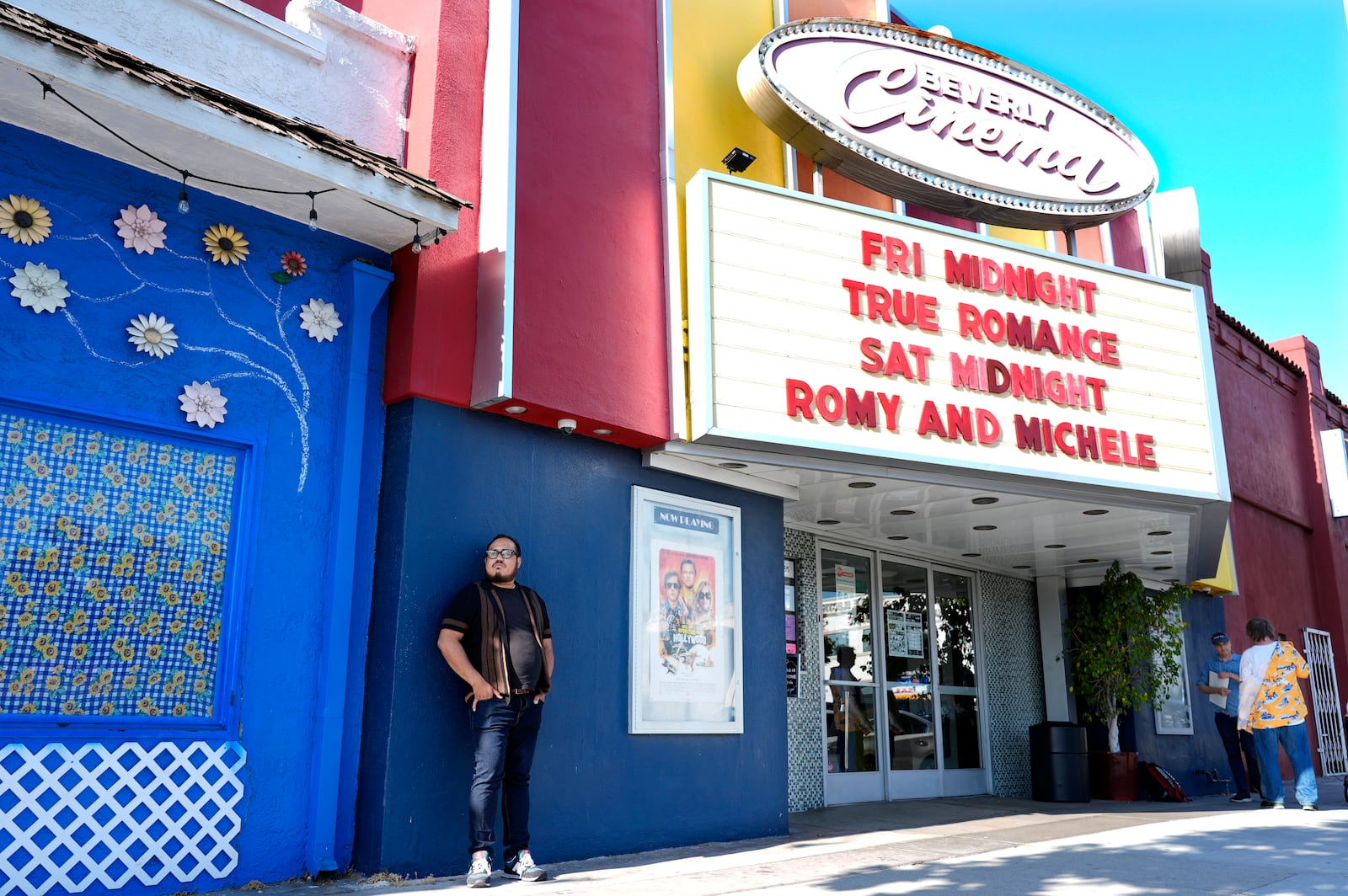 Cinephile Miles Villalon, left, stands underneath the marquee of the New Beverly Cinema revival theater, Friday, Aug. 9, 2024, in Los Angeles. (AP Photo/Chris Pizzello)