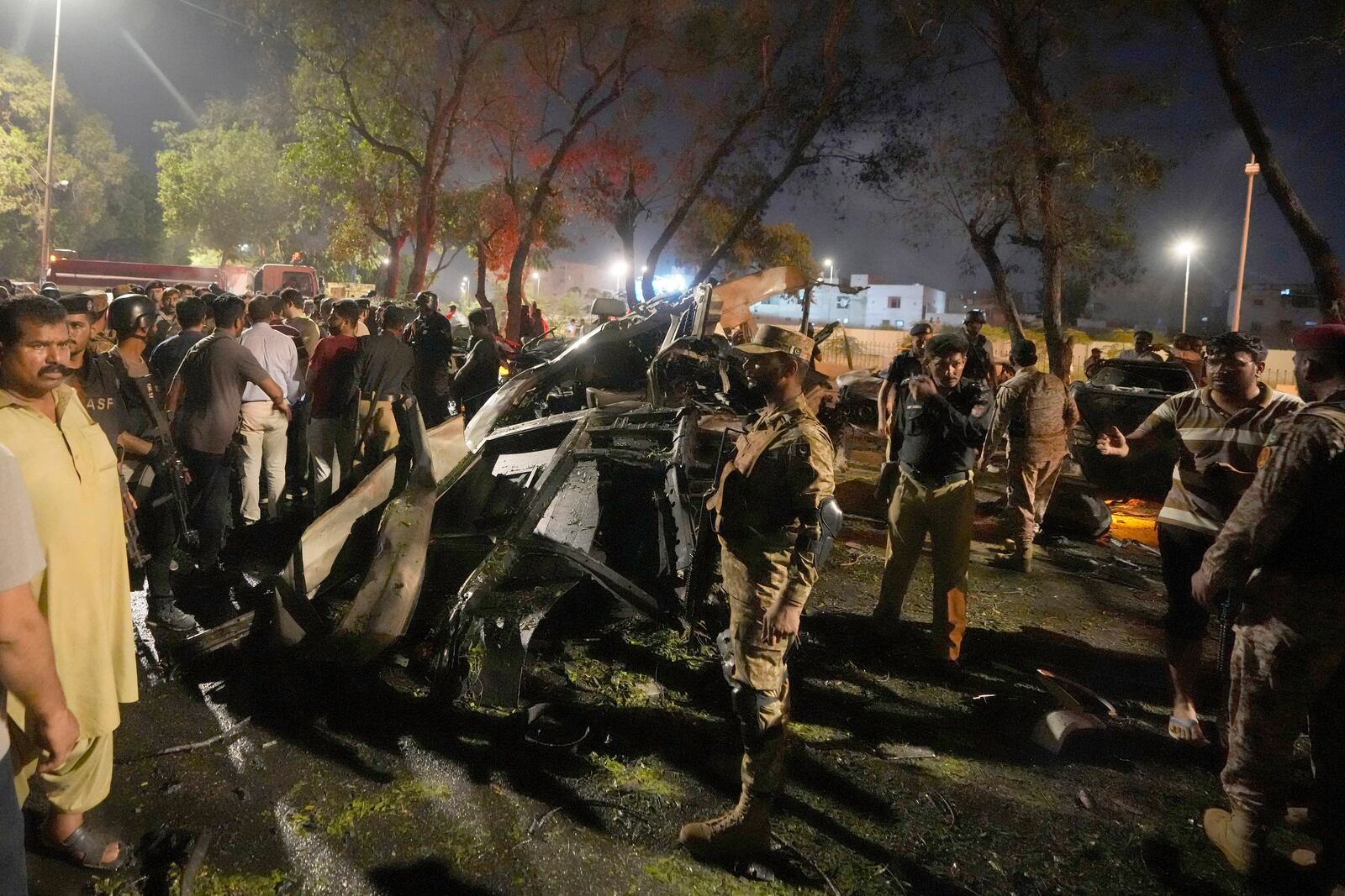 Security officials examine the site of an explosion that caused injures and destroyed vehicles outside Karachi airport, Pakistan, early Monday, Oct. 7, 2024. (AP Photo/Fareed Khan)