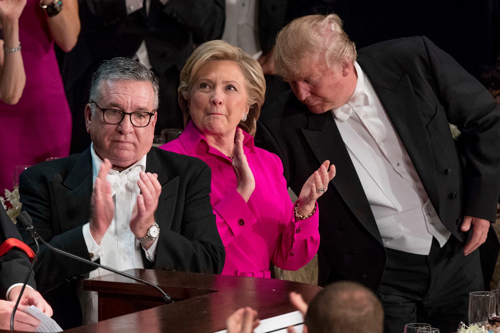 FILE - From left, Alfred E. Smith IV, Democratic presidential candidate Hillary Clinton, and Republican presidential candidate Donald Trump stand to applaud during the 71st annual Alfred E. Smith Memorial Foundation Dinner, Thursday, Oct. 20, 2016, in New York. (AP Photo/Andrew Harnik, File)