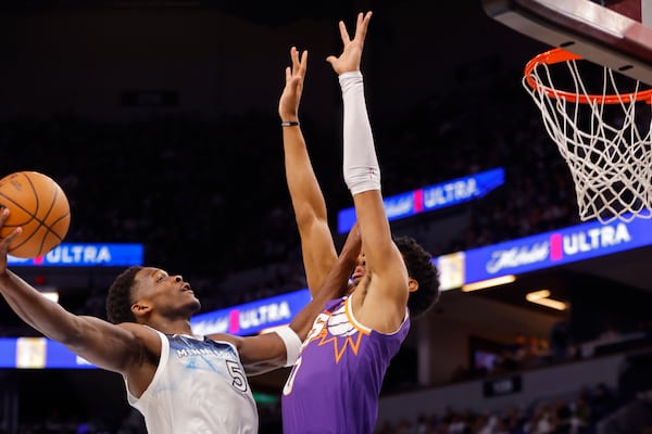 Minnesota Timberwolves guard Anthony Edwards (5) goes to the basket against Phoenix Suns forward Royce O'Neale (0) in the first quarter of an NBA basketball game Sunday, Nov. 17, 2024, in Minneapolis. (AP Photo/Bruce Kluckhohn)