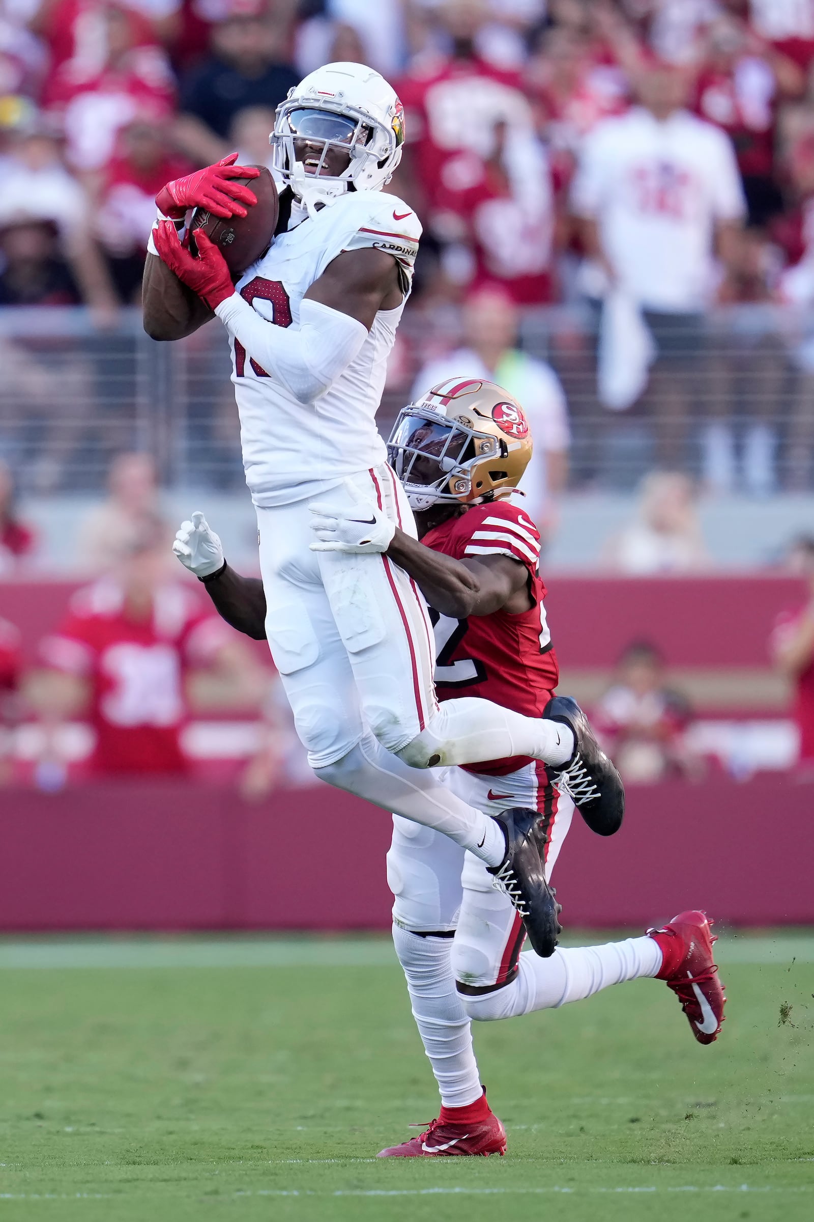 Arizona Cardinals wide receiver Marvin Harrison Jr., top, catches a pass in front of San Francisco 49ers cornerback Isaac Yiadom during the second half of an NFL football game in Santa Clara, Calif., Sunday, Oct. 6, 2024. (AP Photo/Godofredo A. Vásquez)