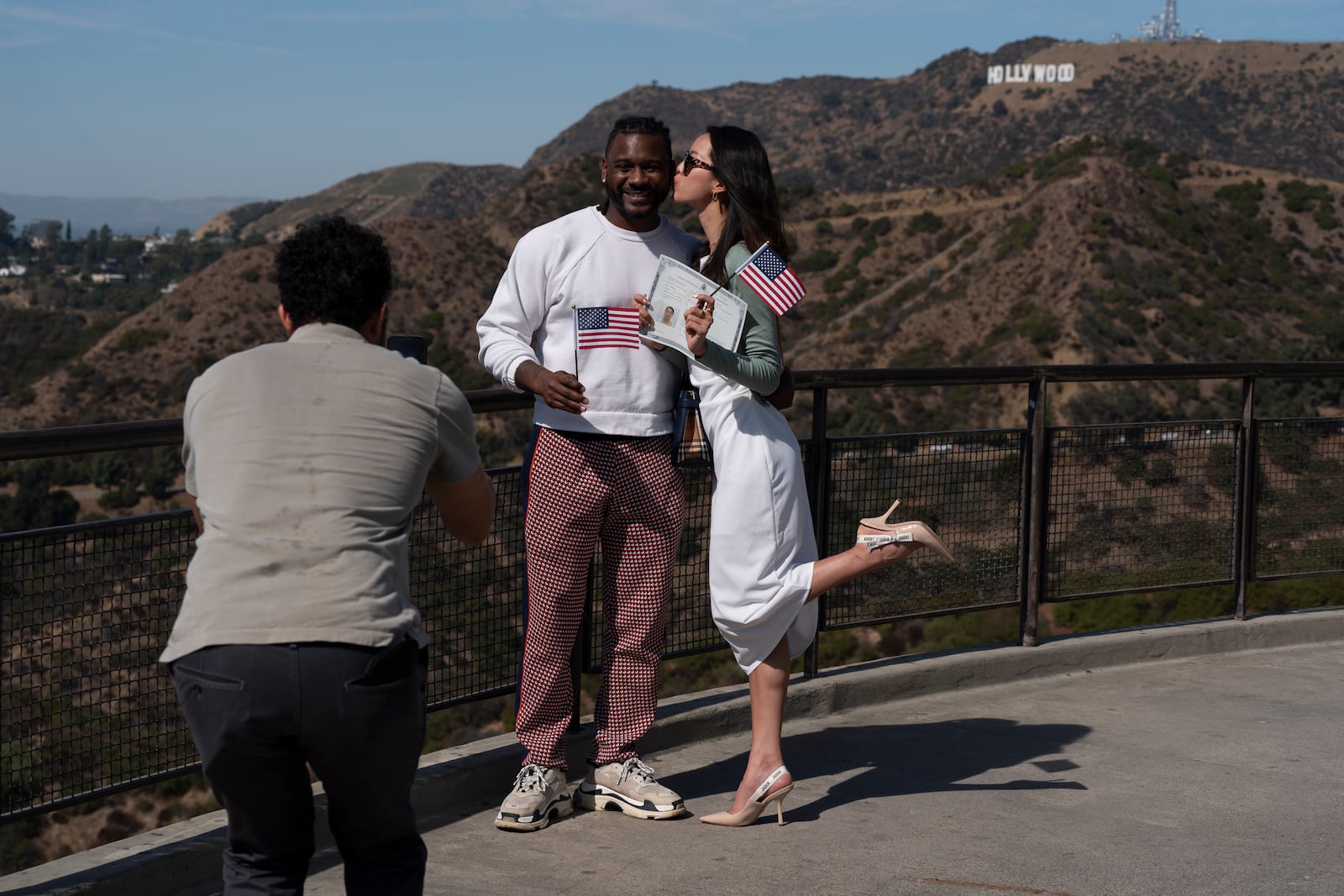 Chia Hsin Tsai kisses her boyfriend, Eric Boyce, while posing for photos with her certificate of citizenship following a naturalization ceremony at Griffith Observatory in Los Angeles, Monday, Oct. 21, 2024. (AP Photo/Jae C. Hong)