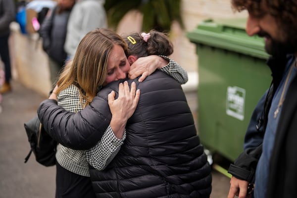 Local residents gather to collect their belongings the day after an apartment building was hit by a rocket fired from Lebanon, in Haifa, Israel, Monday, Nov. 25, 2024. (AP Photo/Francisco Seco)