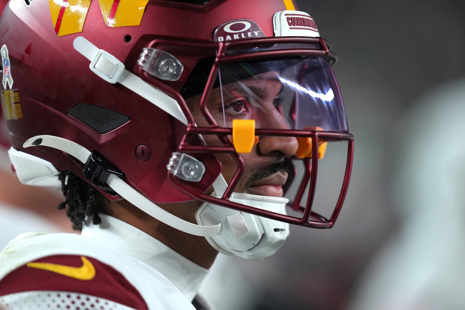 Washington Commanders quarterback Jayden Daniels watches from the sideline during the second half of an NFL football game against the Philadelphia Eagles Thursday, Nov. 14, 2024, in Philadelphia. (AP Photo/Chris Szagola)