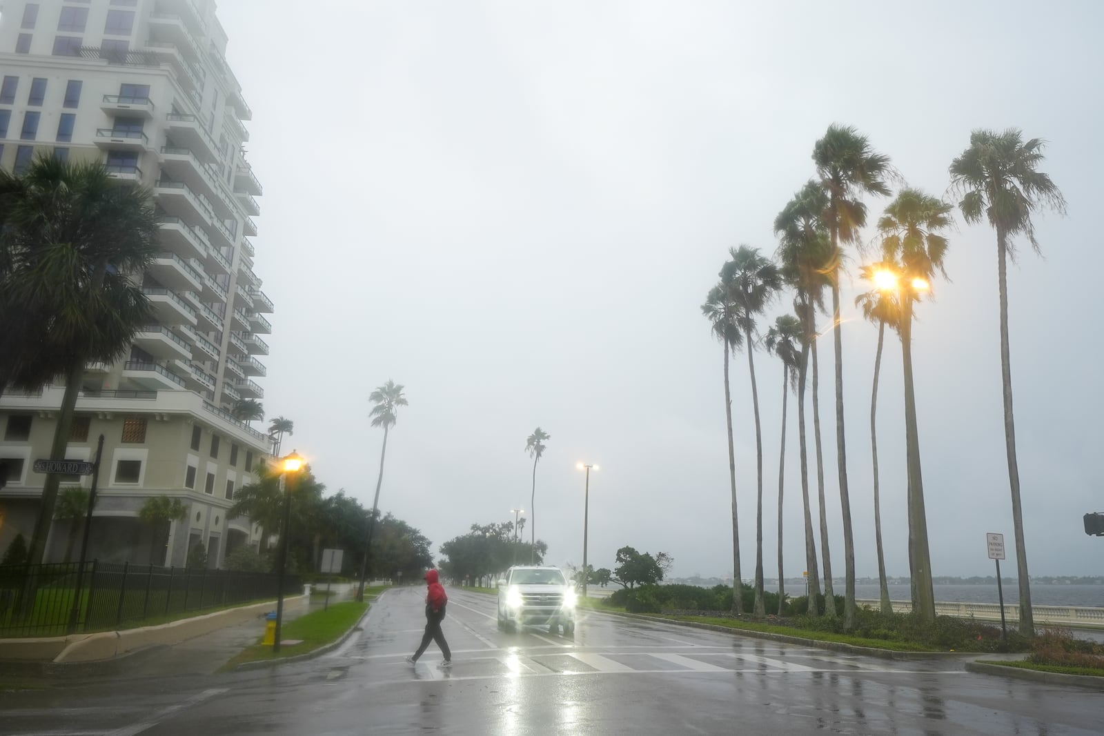 A person walks under light rain ahead of the arrival of Hurricane Milton, Wednesday, Oct. 9, 2024, in Tampa, Fla. (AP Photo/Julio Cortez)