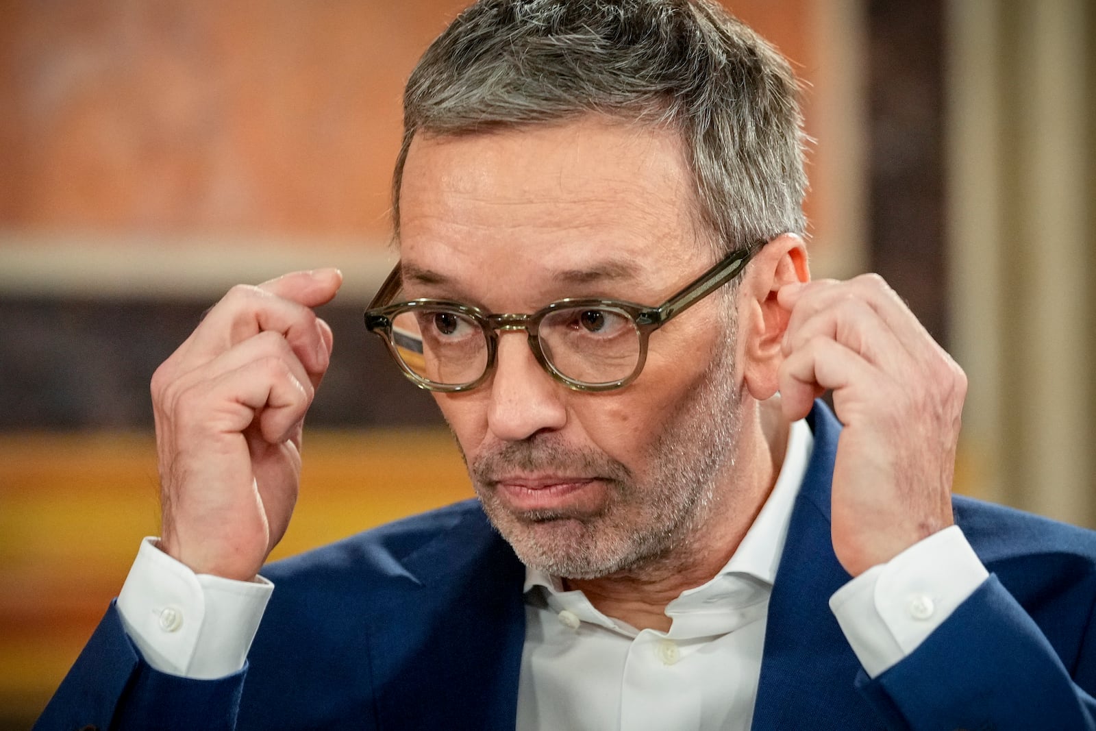 Herbert Kickl, leader of the Freedom Party of Austria adjusts his glasses at the national broadcaster studio, set up in the parliament building, in Vienna, Austria, Sunday, Sept. 29, 2024, after polls closed in the country's national election. (AP Photo/Andreea Alexandru)