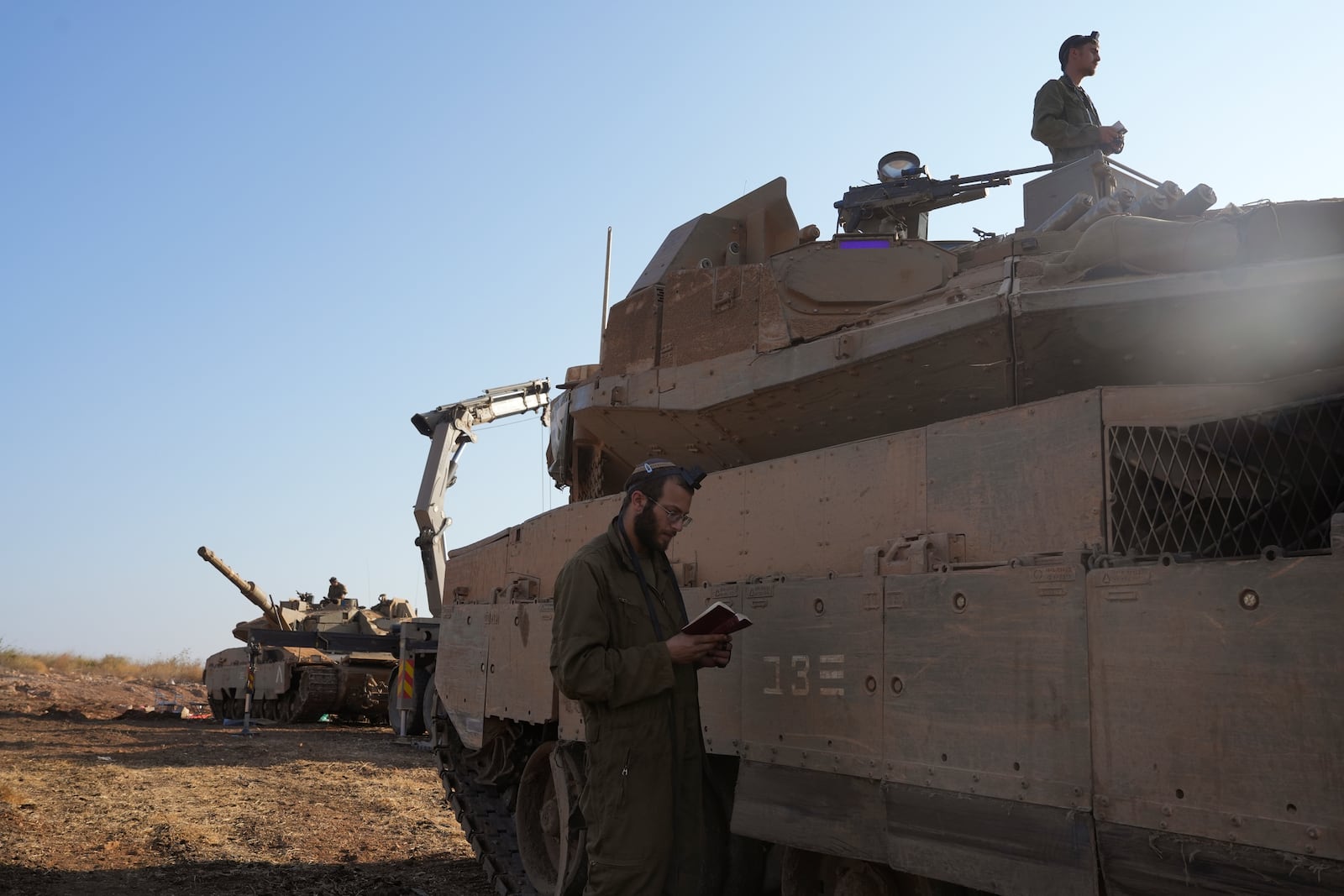 Israeli soldiers pray at a staging area in northern Israel, Sunday, Oct. 6, 2024. (AP Photo/Baz Ratner)