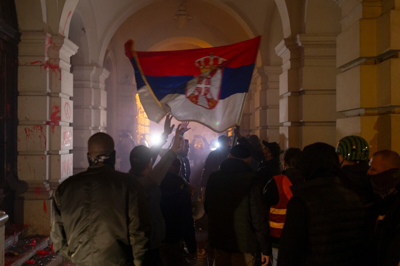 Protesters carry a Serbian flag outside the City Hall building, during a protest in rage over last week's collapse of a concrete canopy at the railway station that killed 14 people, in Novi Sad, Serbia, Tuesday, Nov. 5, 2024. (AP Photo/Marko Drobnjakovic)