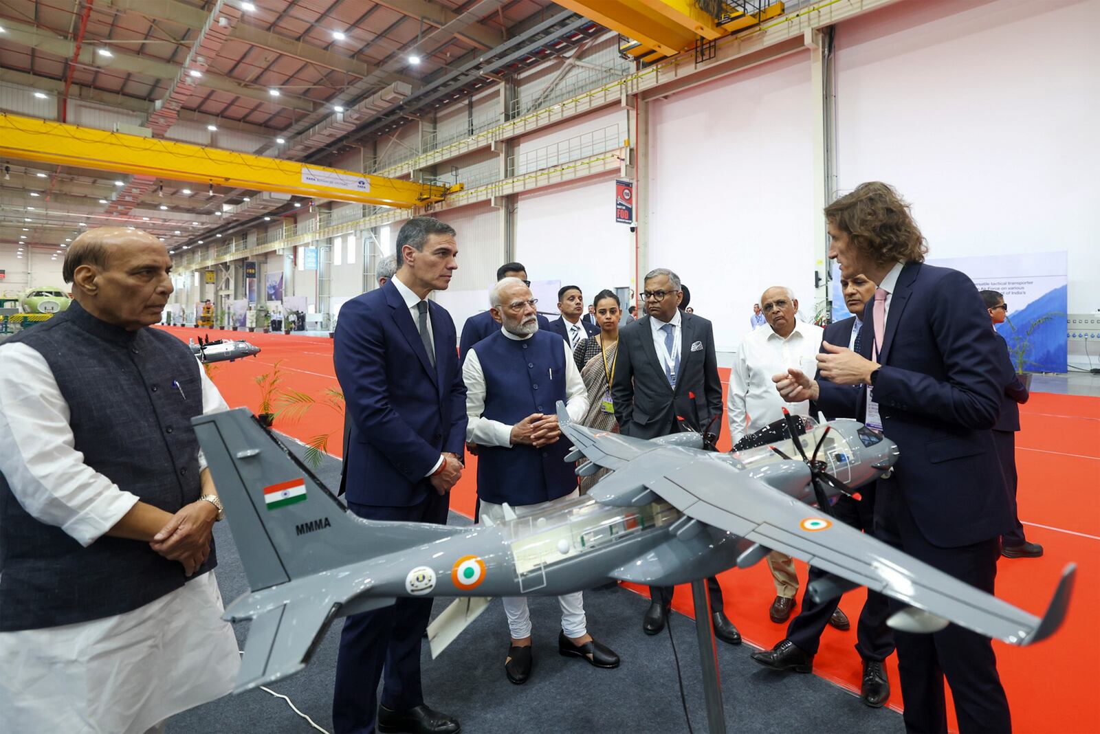 In this handout photo provided by the Press Information Bureau, Indian Prime Minister Narendra Modi, third left, and his Spanish counterpart Pedro Sanchez, second left, listen to an aide at the exhibition after inaugurating India's first private military aircraft plant in Vadodara, India, Monday, Oct. 28, 2024. (Press Information Bureau via AP)