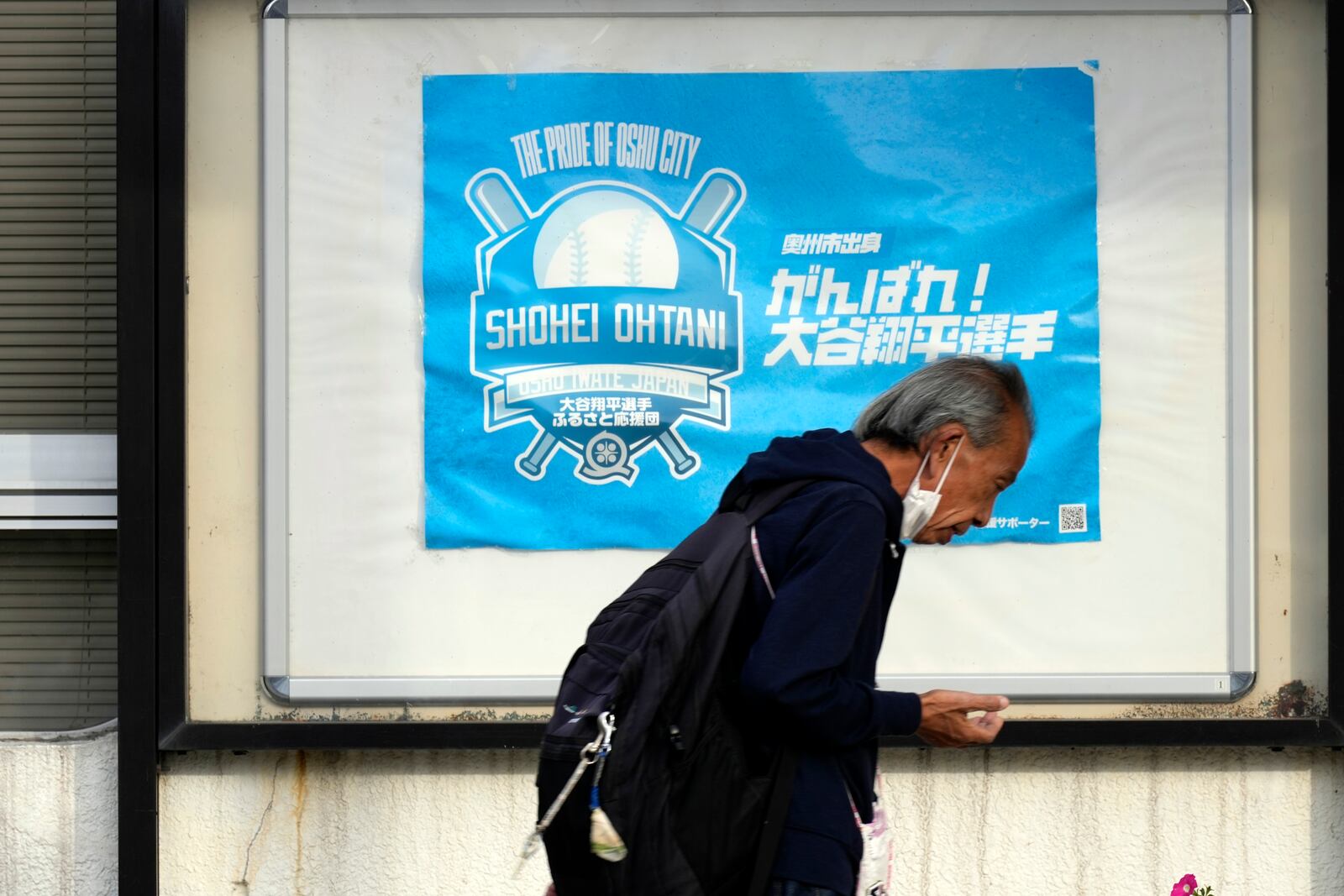 A person walks past the city's poster to support Shohei Ohtani of the Los Angeles Dodgers, near Mizusawa train station in Oshu, northeastern Japan, the hometown of Ohtani, Tuesday, Oct. 29, 2024. (AP Photo/Eugene Hoshiko)