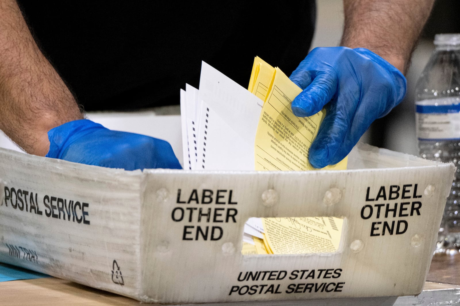 FILE - Elections workers process absentee ballots for a U.S. Senate runoff election in Atlanta, Jan. 5, 2021. (AP Photo/Ben Gray, File)