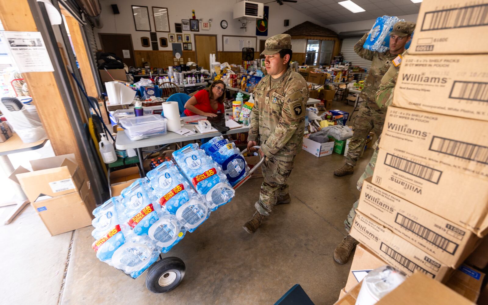 Soldiers with the 101st Airborne Division Air Assault, 2nd Brigade Combat Team, from Fort Campbell, Ky., help volunteers distribute water, food, toiletries, and other aid to residents in Maggie Valley on Tuesday, Oct. 8, 2024. (Travis Long/The News & Observer via AP)