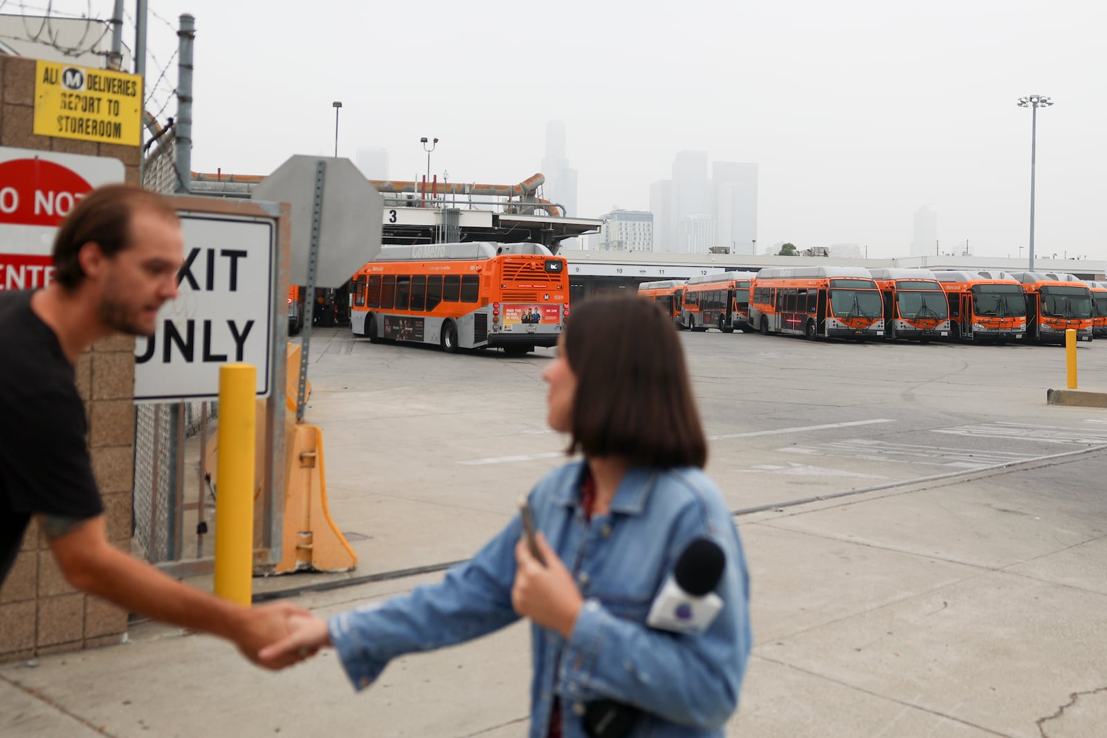 News media prepare to go live in front of a Los Angeles MTA bus depot near the site where overnight a bus was hijacked by an armed subject with passengers on board Wednesday, Sept. 25, 2024, in Los Angeles. One person was fatally shot before police apprehended the suspect. (AP Photo/Ryan Sun)