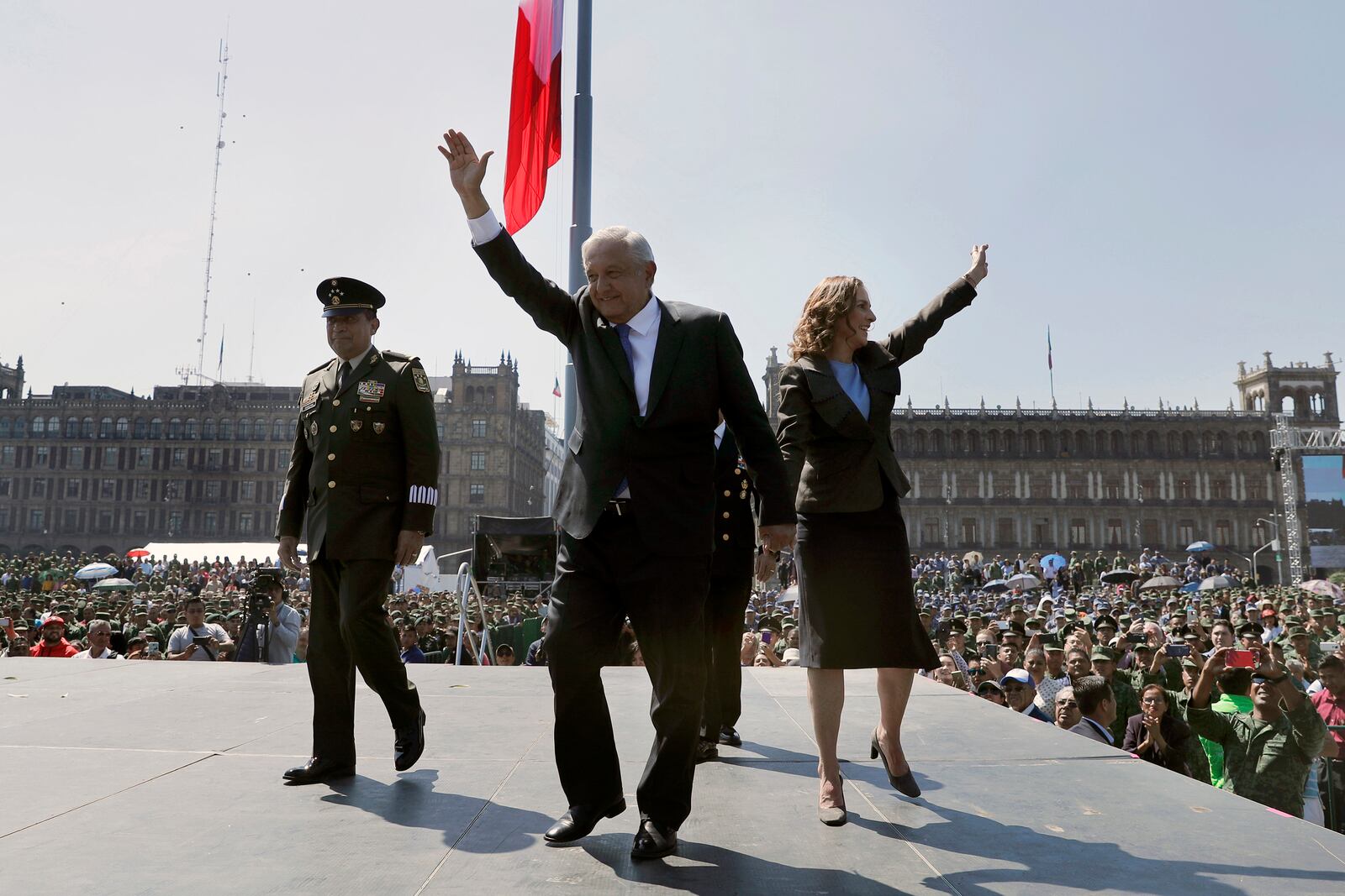 FILE - Mexican President Andres Manuel Lopez Obrador and first lady Beatriz Gutierrez Muller wave during an event marking the Army Day at the Zocalo in Mexico City, Feb. 19, 2020. (AP Photo/Marco Ugarte, File)