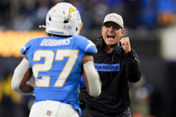 Los Angeles Chargers head coach Jim Harbaugh, right, celebrates after a rushing touchdown by running back J.K. Dobbins (27) during the first half of an NFL football game against the Cincinnati Bengals, Sunday, Nov. 17, 2024, in Inglewood, Calif. (AP Photo/Gregory Bull)