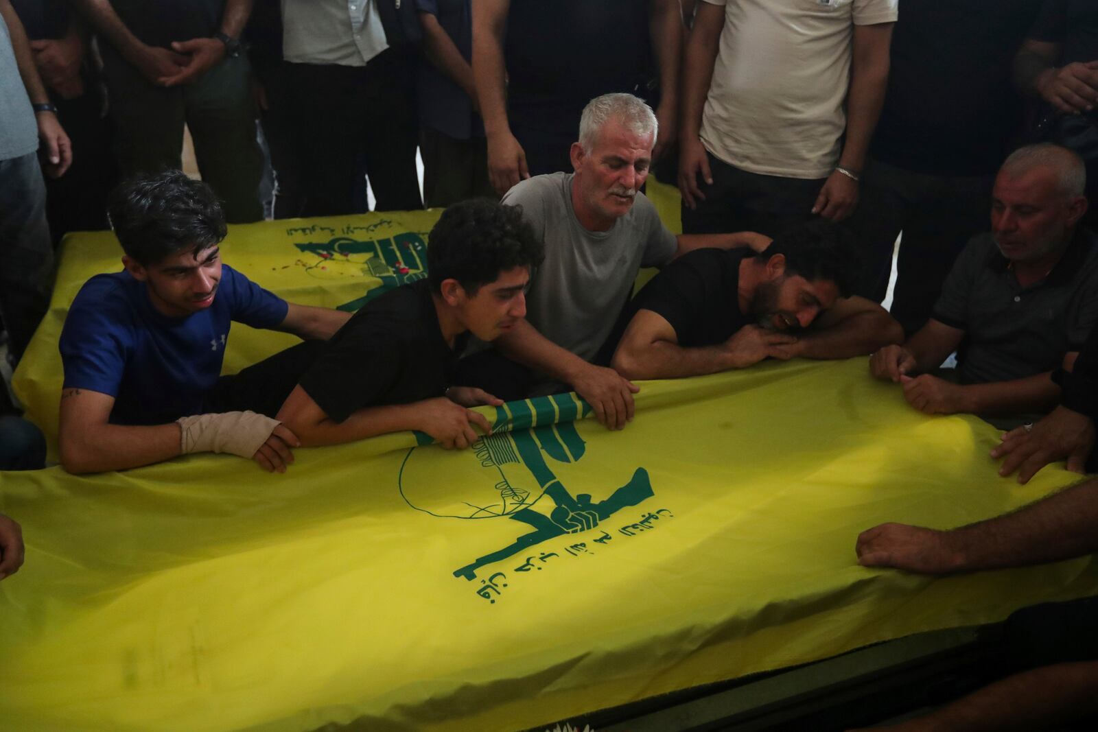 Relatives mourn over the coffins of Hezbollah members who were killed in an Israeli airstrikes, during their funeral procession in the southern village of Saksakieh, Lebanon, Tuesday, Sept. 24, 2024. (AP Photo/Mohammed Zaatari)