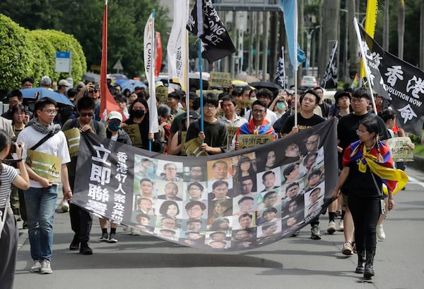 FILE- Hong Kong activists and supporters march with a banner which reads " Unite now in solidarity with the Hong Kong 47 and other political prisoners" during a protest commemorating the 10th anniversary of the 2014 umbrella movement and the fifth anniversary of the anti-extradition law amendment bill movement in Taipei, Taiwan, June 9, 2024. (AP Photo/Chiang Ying-ying, File)