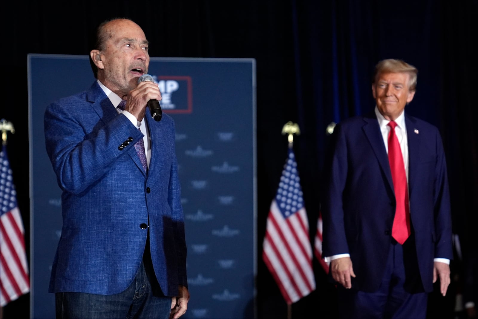 Republican presidential nominee former President Donald Trump listens to Lee Greenwood sing at a faith event at the Concord Convention Center, Monday, Oct. 21, 2024, in Concord, N.C. (AP Photo/Evan Vucci)