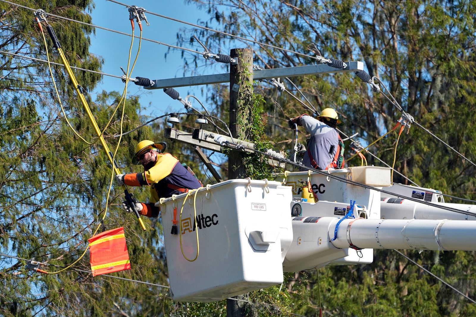 Pike Corporation linemen, from North Carolina, work on power lines damaged by Hurricane Milton Monday, Oct. 14, 2024, in Lithia, Fla. (AP Photo/Chris O'Meara)