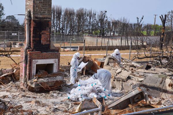 Cal/OSHA workers remove hazardous materials from a home destroyed by the Palisades Fire in the Pacific Palisades neighborhood of Los Angeles, Thursday, April 24, 2025. (AP Photo/Damian Dovarganes)