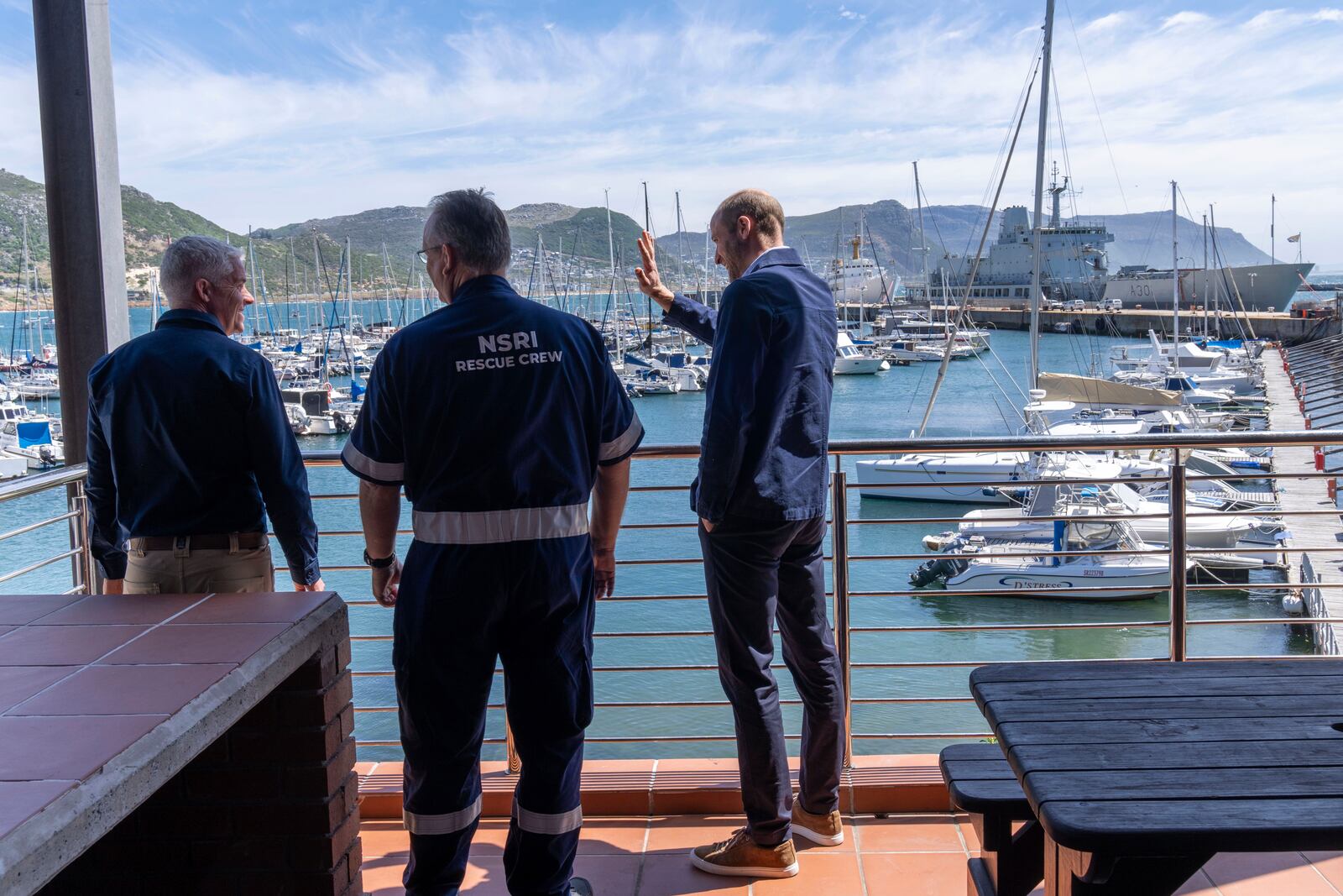 Britain's Prince William waves to well-wishers during his visit with volunteers of the National Sea Rescue Initiative, at Simon's Town harbour near Cape Town, South Africa, Thursday, Nov. 7, 2024. (AP Photo/Jerome Delay, Pool)