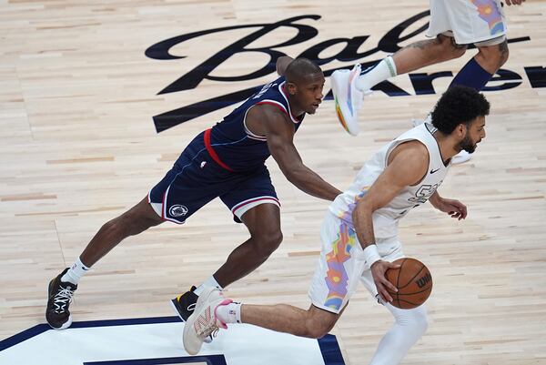 Denver Nuggets guard Jamal Murray, right, drives past Los Angeles Clippers guard Kris Dunn in the first half of Game 5 of an NBA basketball playoff series Tuesday, April 29, 2025, in Denver. (AP Photo/David Zalubowski)