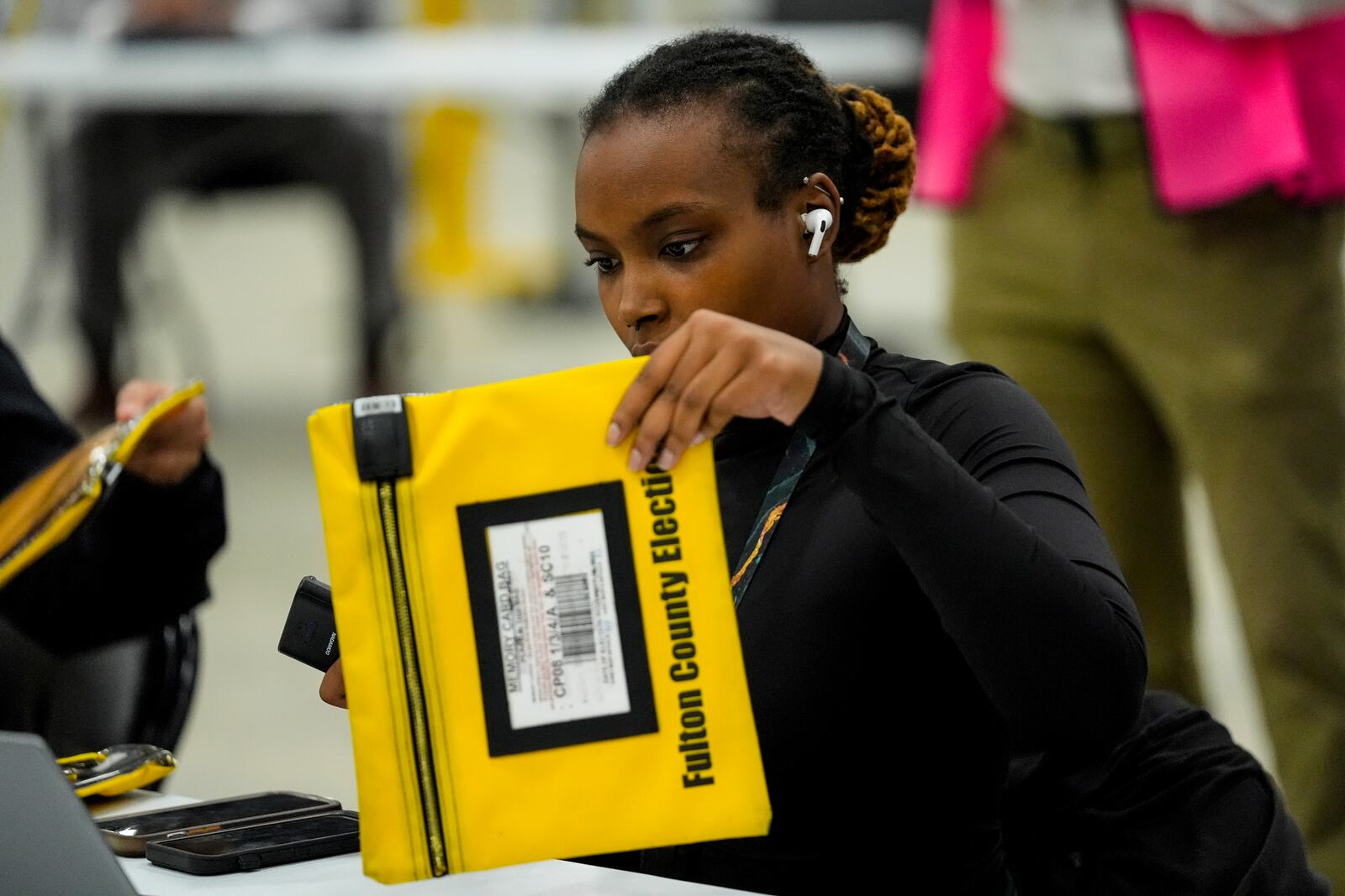 An election worker scans an envelope that holds a voting machine memory card at the Fulton County Election Hub and Operation Center, Tuesday, Nov. 5, 2024, in Atlanta. (AP Photo/John Bazemore)