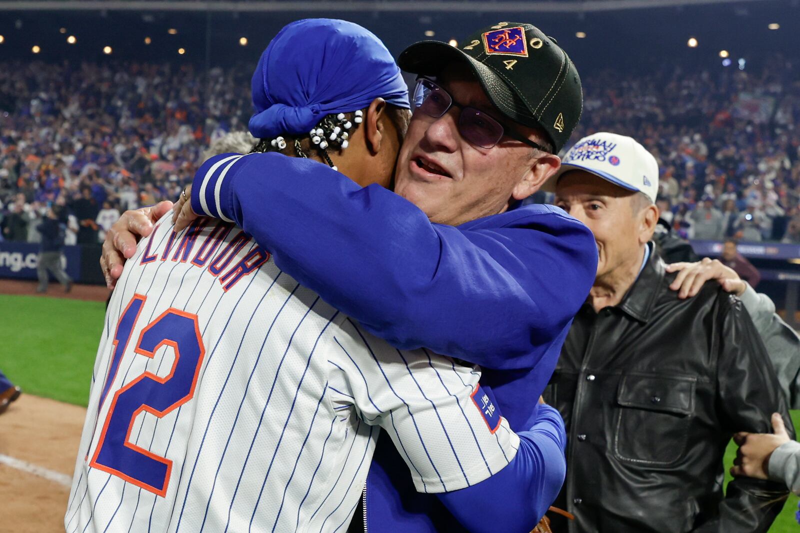 New York Mets shortstop Francisco Lindor (12) hugs owner Steve Cohen after the Mets defeated the Philadelphia Phillies in Game 4 of the National League baseball playoff series, Wednesday, Oct. 9, 2024, in New York. (AP Photo/Adam Hunger)