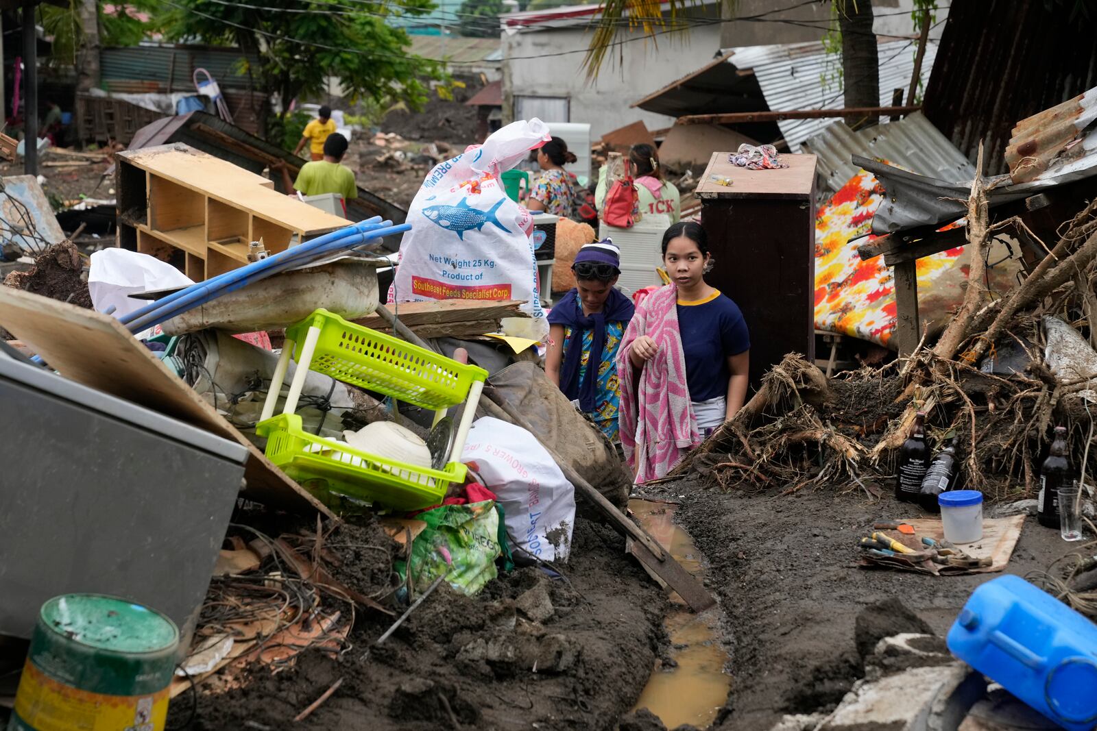 Residents try to recover belongings from their damaged homes after a recent landslide triggered by Tropical Storm Trami struck Talisay, Batangas province, Philippines leaving thousands homeless and several villagers dead on Saturday, Oct. 26, 2024. (AP Photo/Aaron Favila)