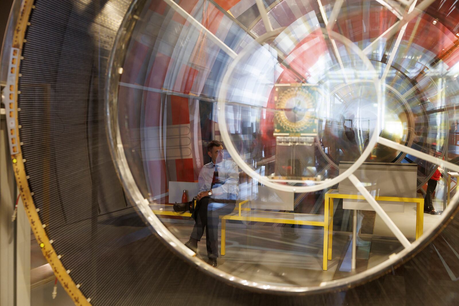 FILE - A guest is reflected in an installation of an exhibition on the occasion of the inauguration ceremony of the Science Gateway Museum, at the the European Organization for Nuclear Research (CERN), in Meyrin near Geneva, Switzerland, Saturday, Oct. 7, 2023. (Salvatore Di Nolfi/Keystone via AP, FILE)