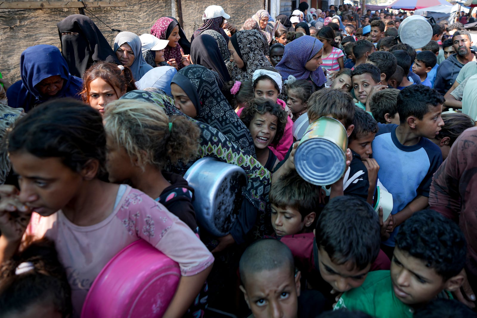 Palestinians line up for food distribution in Deir al-Balah, Gaza Strip, Thursday, Oct. 17, 2024. (AP Photo/Abdel Kareem Hana)