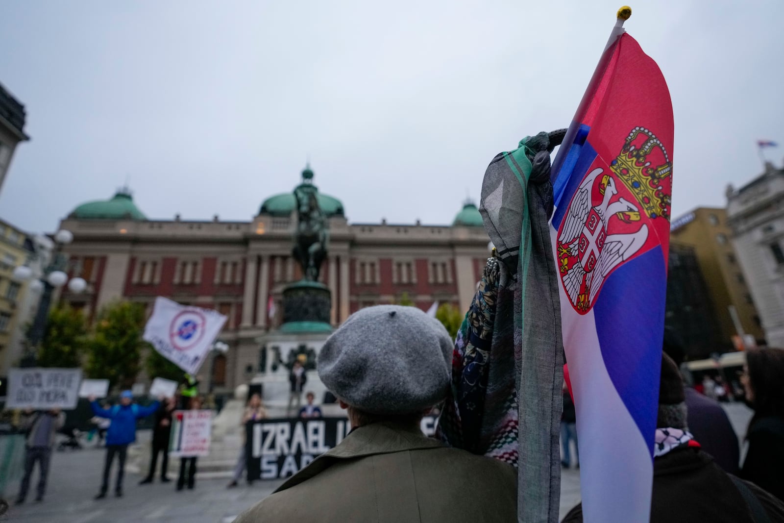 A woman holds a Serbian flag during a pro-Palestinian gathering in Belgrade, Serbia, Saturday, Oct. 5, 2024. (AP Photo/Darko Vojinovic)