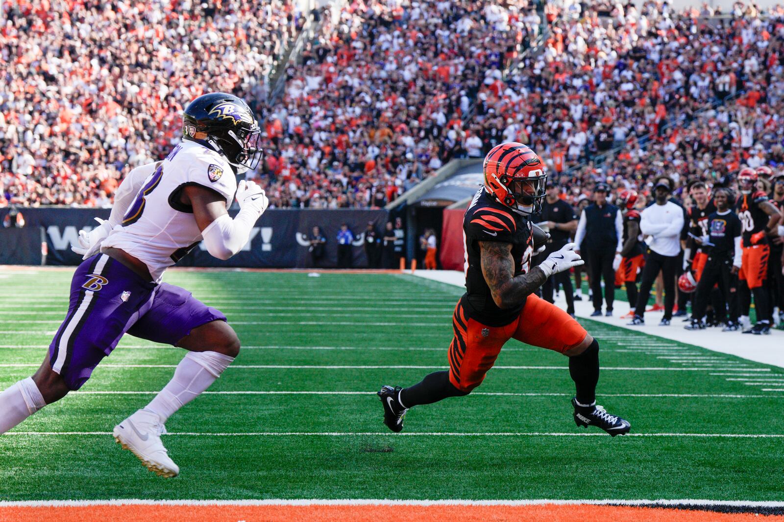 Cincinnati Bengals running back Chase Brown, right, runs in a touchdown after making a catch in front of Baltimore Ravens linebacker Trenton Simpson during the second half of an NFL football game, Sunday, Oct. 6, 2024, in Cincinnati. (AP Photo/Jeff Dean)