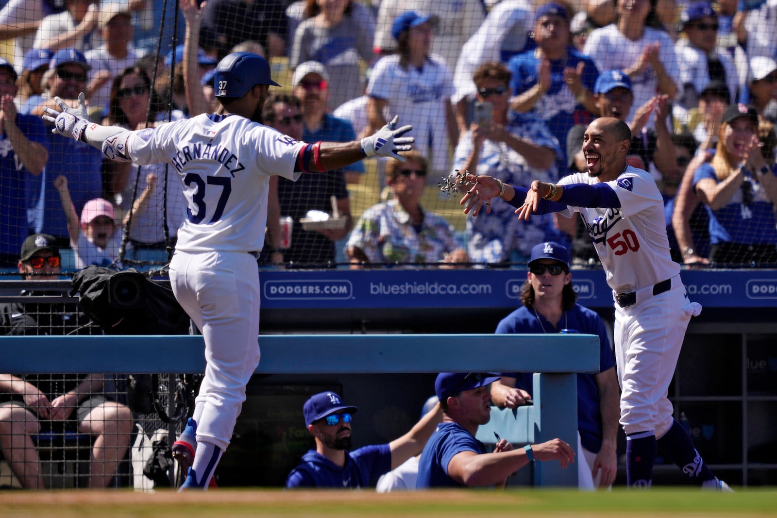 Los Angeles Dodgers' Teoscar Hernández, left, has sunflower seeds thrown at him by Mookie Betts after hitting a solo home run during the fourth inning of a baseball game against the Colorado Rockies, Sunday, Sept. 22, 2024, in Los Angeles. (AP Photo/Mark J. Terrill)